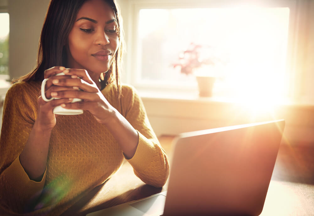 Person working at home with coffee mug by window