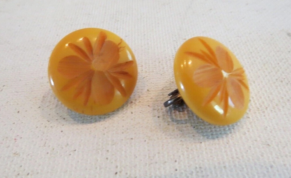 Pair of butterscotch Bakelite button earrings carved with flowers
