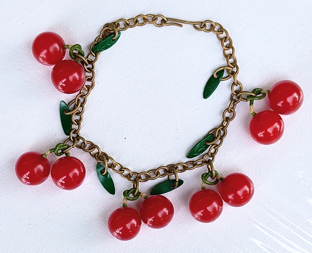 Brass-chain bracelet with five pairs of red Bakelite cherries and green leaf charms