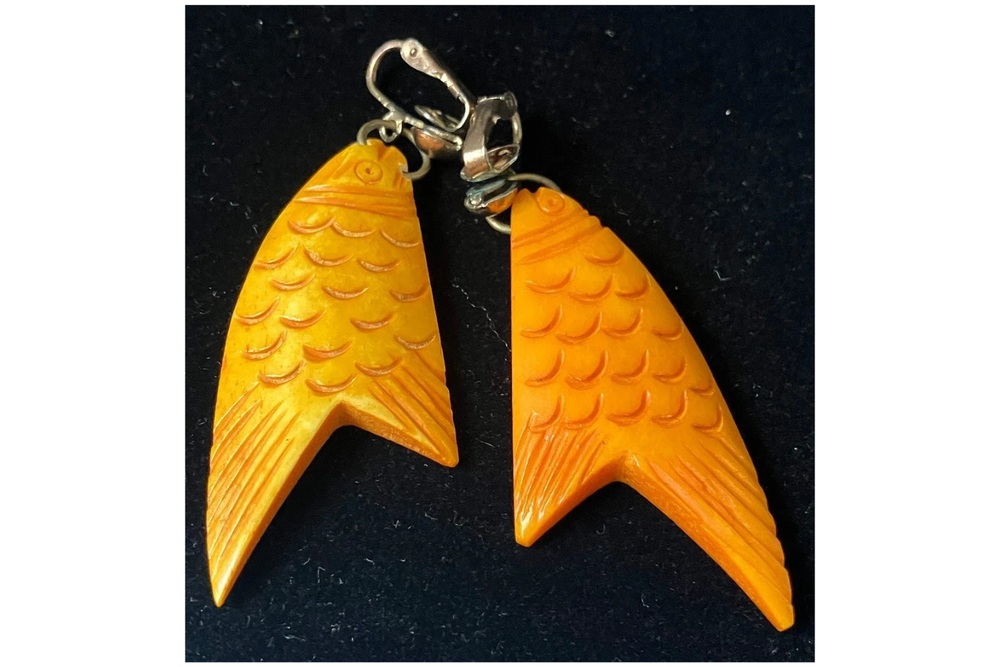 Pair of orange Bakelite fish earrings with carved scales and metal clip-on fittings