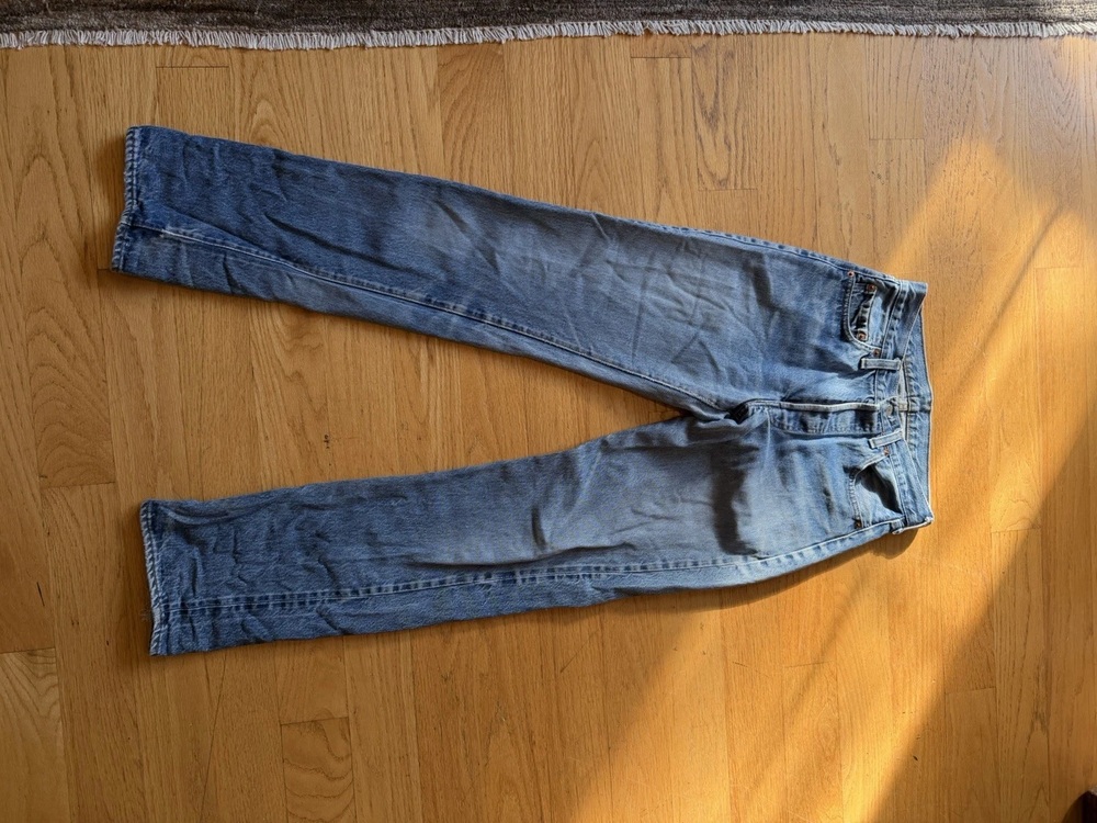 Vintage 1982 Levi's redline selvedge 501 jeans laid flat on a wood floor