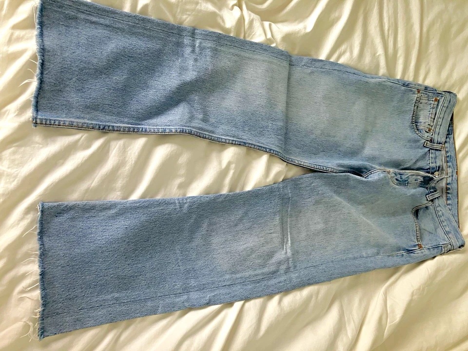 American-made 1990s Levi's 501 jeans laid flat on cream fabric