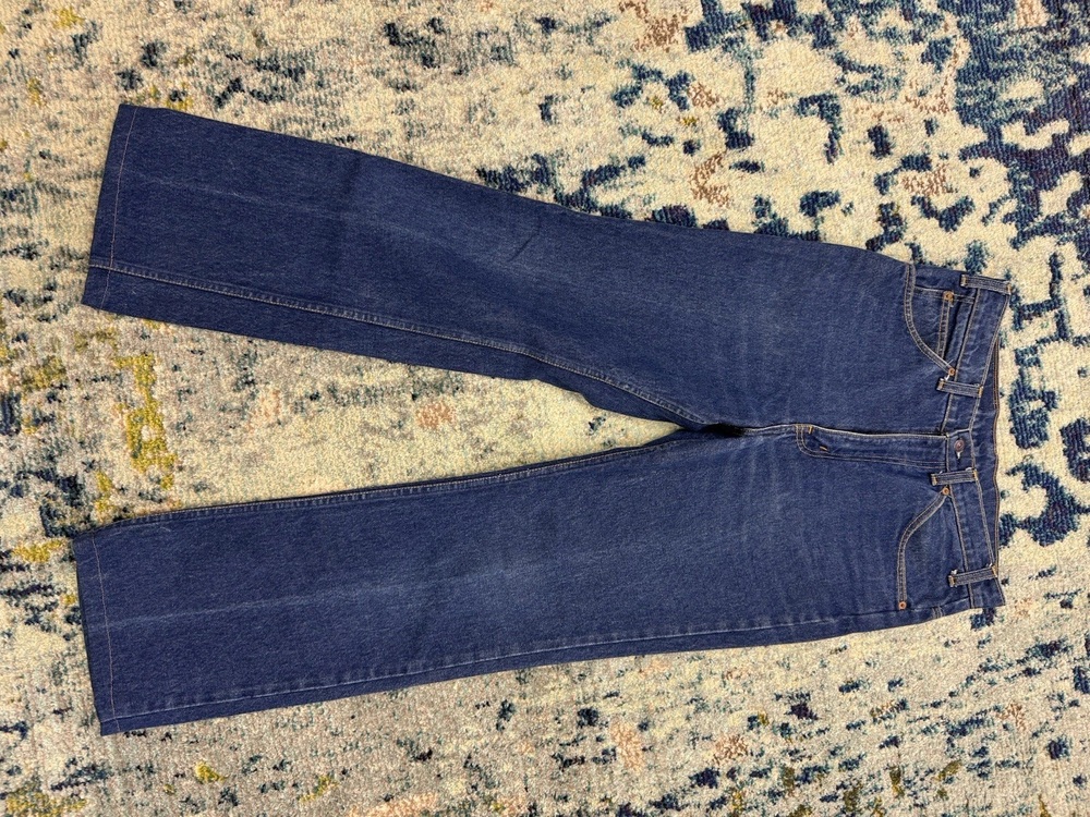 Dark indigo 1979 Levi's 517 boot-cut jeans laid flat on a patterned rug