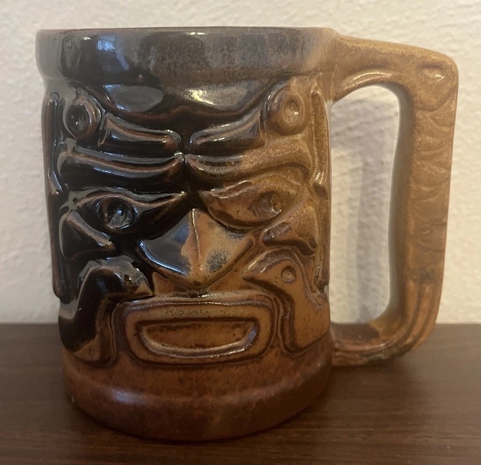 Treasure Craft Hawaii brown and black tiki mug with a carved face