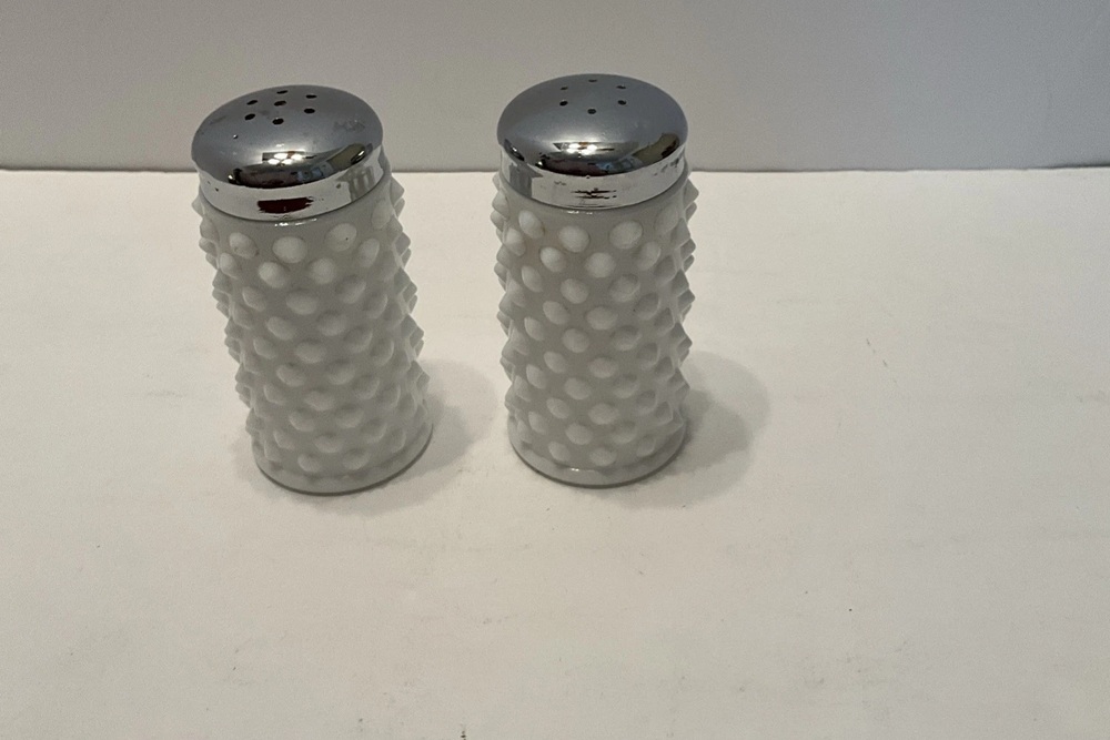 White Fenton hobnail milk glass shakers with perforated metal lids.