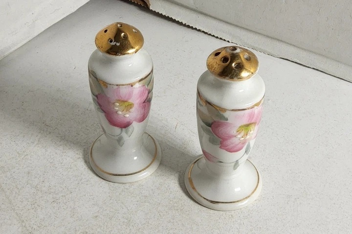 Noritake Azalea shakers with pink flowers and gold-colored tops.