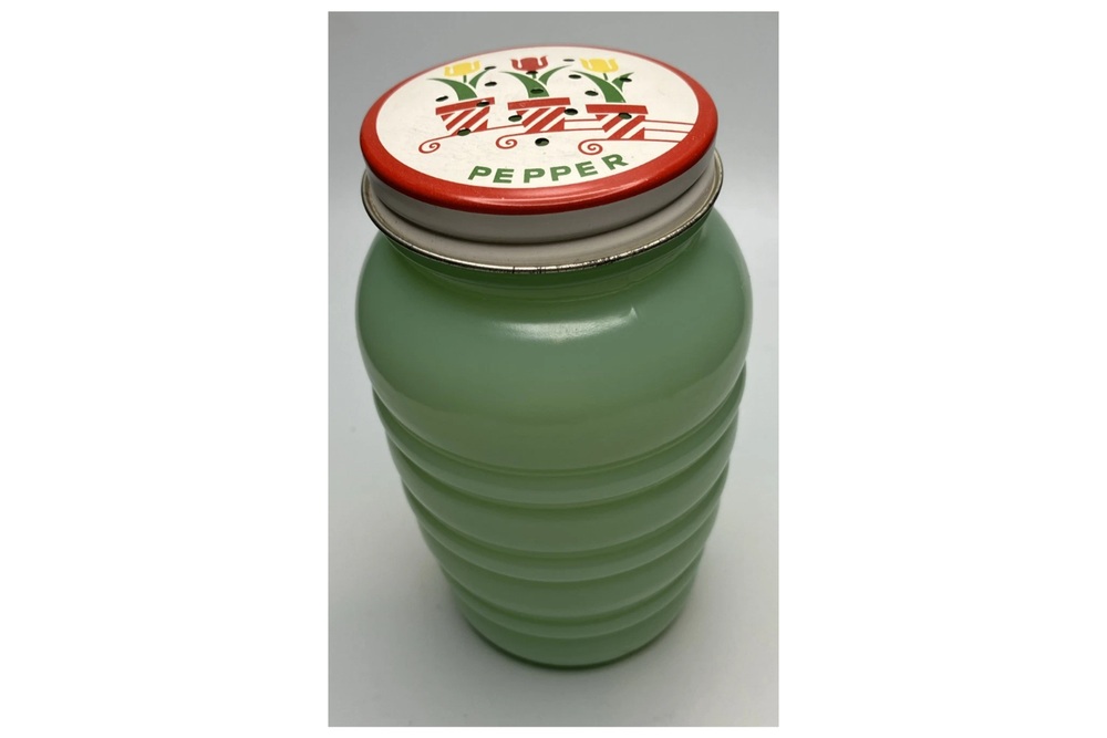 Green Fire-King jadeite pepper shaker with a tulip-decorated metal lid.