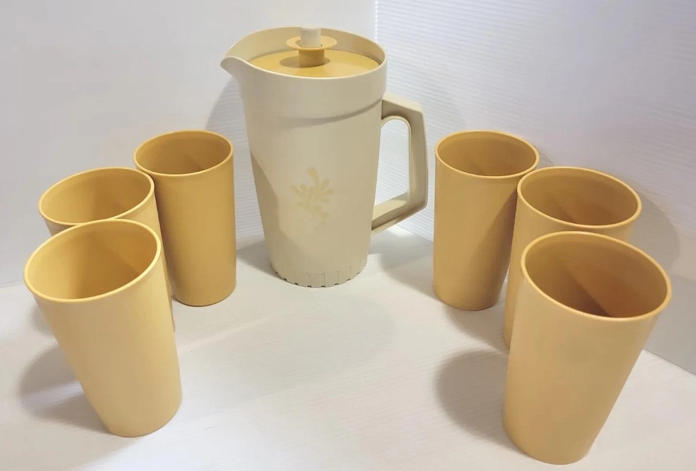 Tupperware push-button pitcher surrounded by six matching tumblers